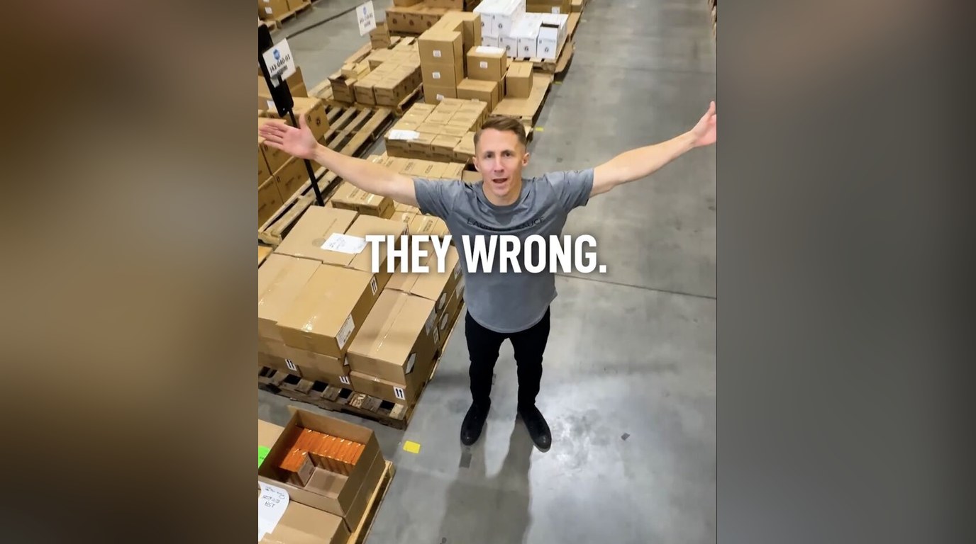 Robert with arms wide in the warehouse under the words "They wrong."