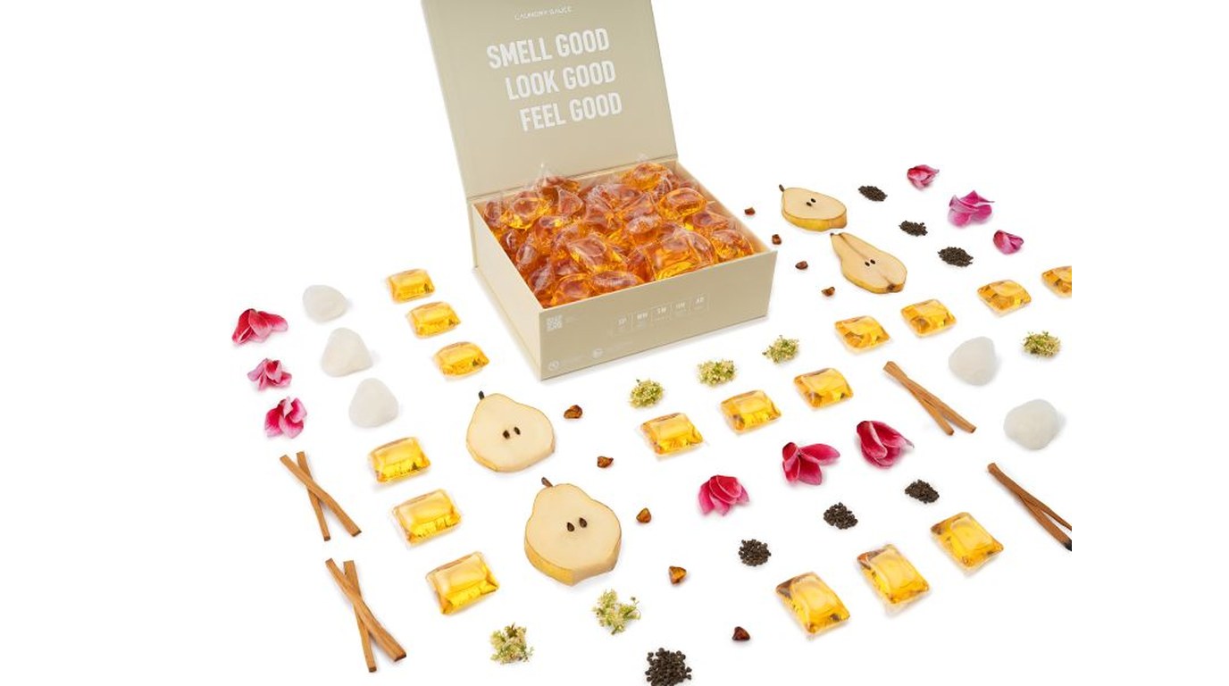 Himalayan Cashmere box with detergent pods and scent ingredients laid out around it