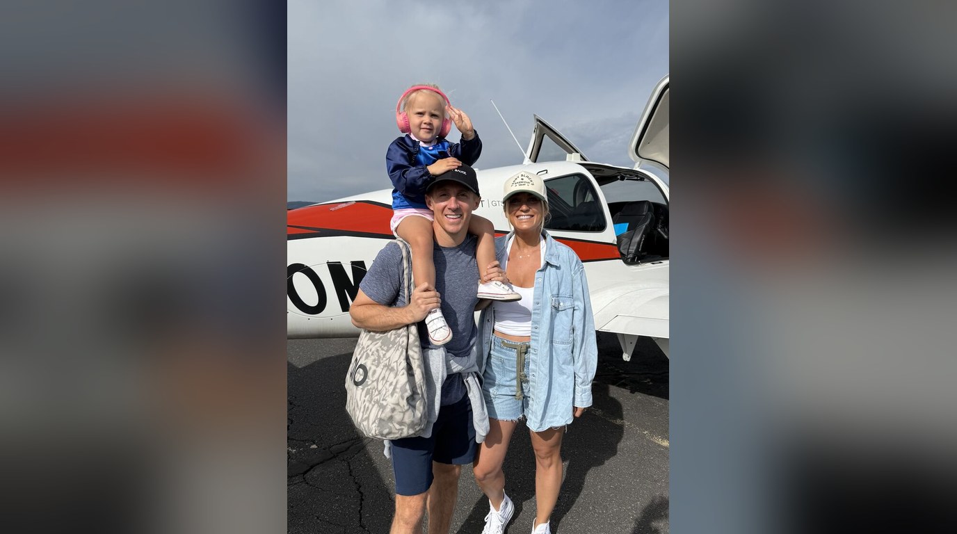 Robert, his wife and daughter standing beside a small plane