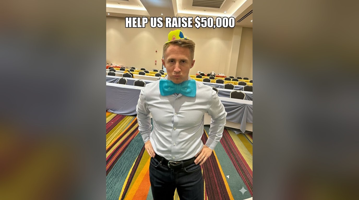 Robert in a teal bow tie at an event under the words "Help us raise $50,000"